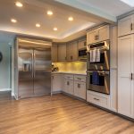 Stainless French-door refrigerator beside a built-in wall oven and microwave stack in a remodeled Claremont kitchen