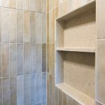 Recessed shower niche with a center shelf, finished in vertical stacked tile